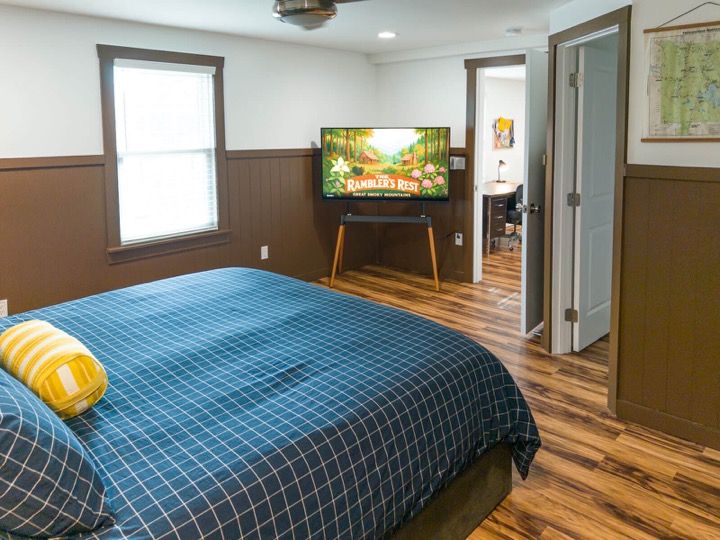 King bedroom with blue checked bedding and a TV