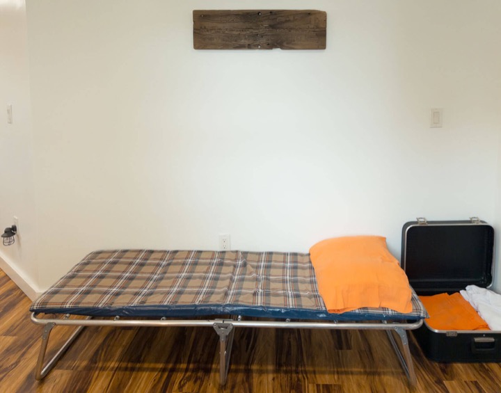 Plaid fold-out cot set up as an extra sleeping space