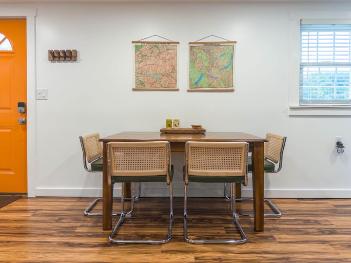 Dining table with woven chairs and vintage-style wall art