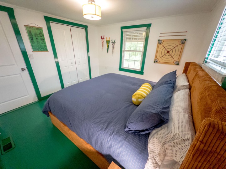 Second bedroom with blue bedding and vintage artwork