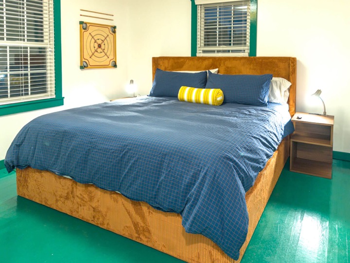 Blue bed in the green-trimmed second bedroom